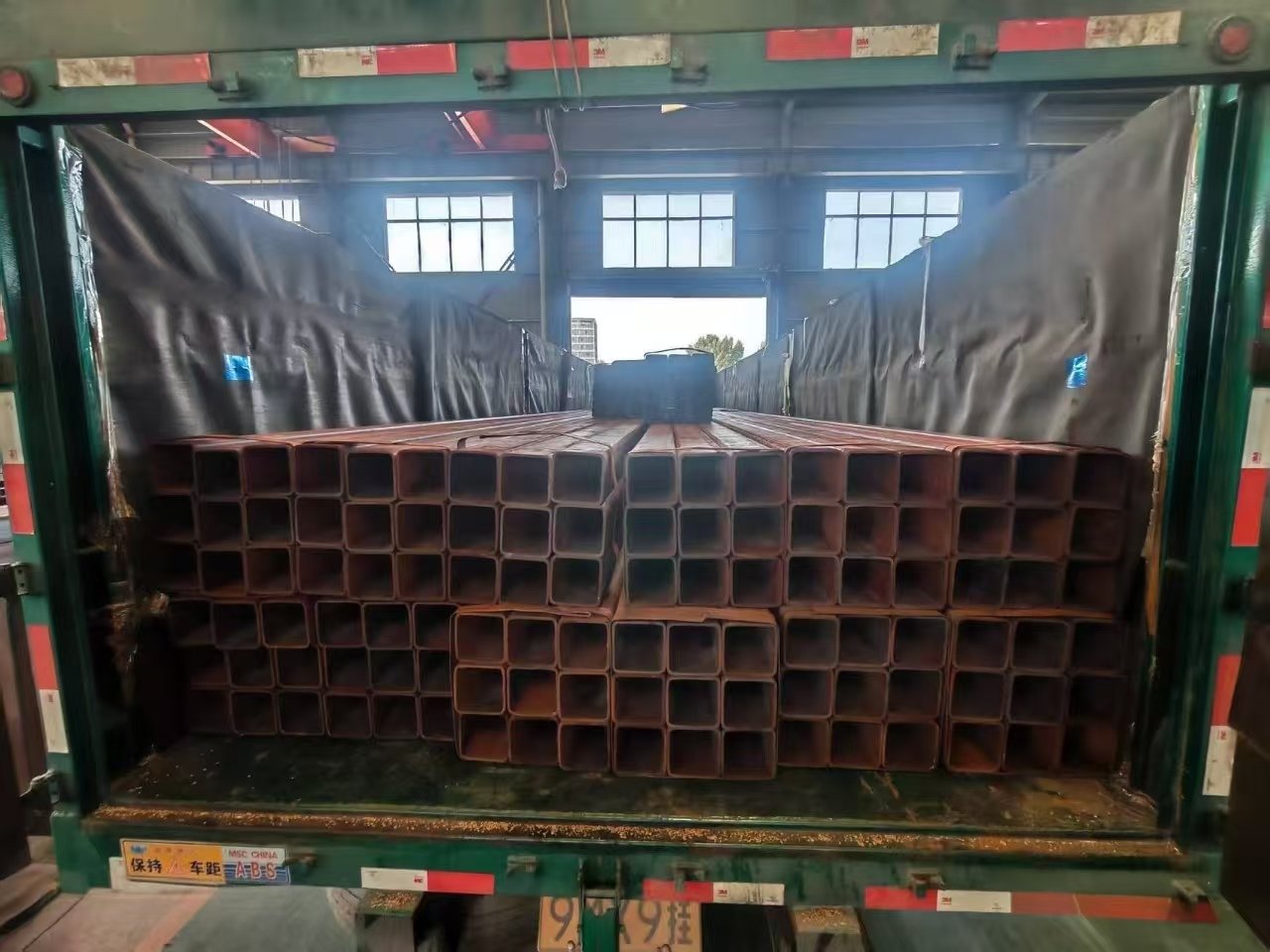 Container being loaded with bundled steel products for export