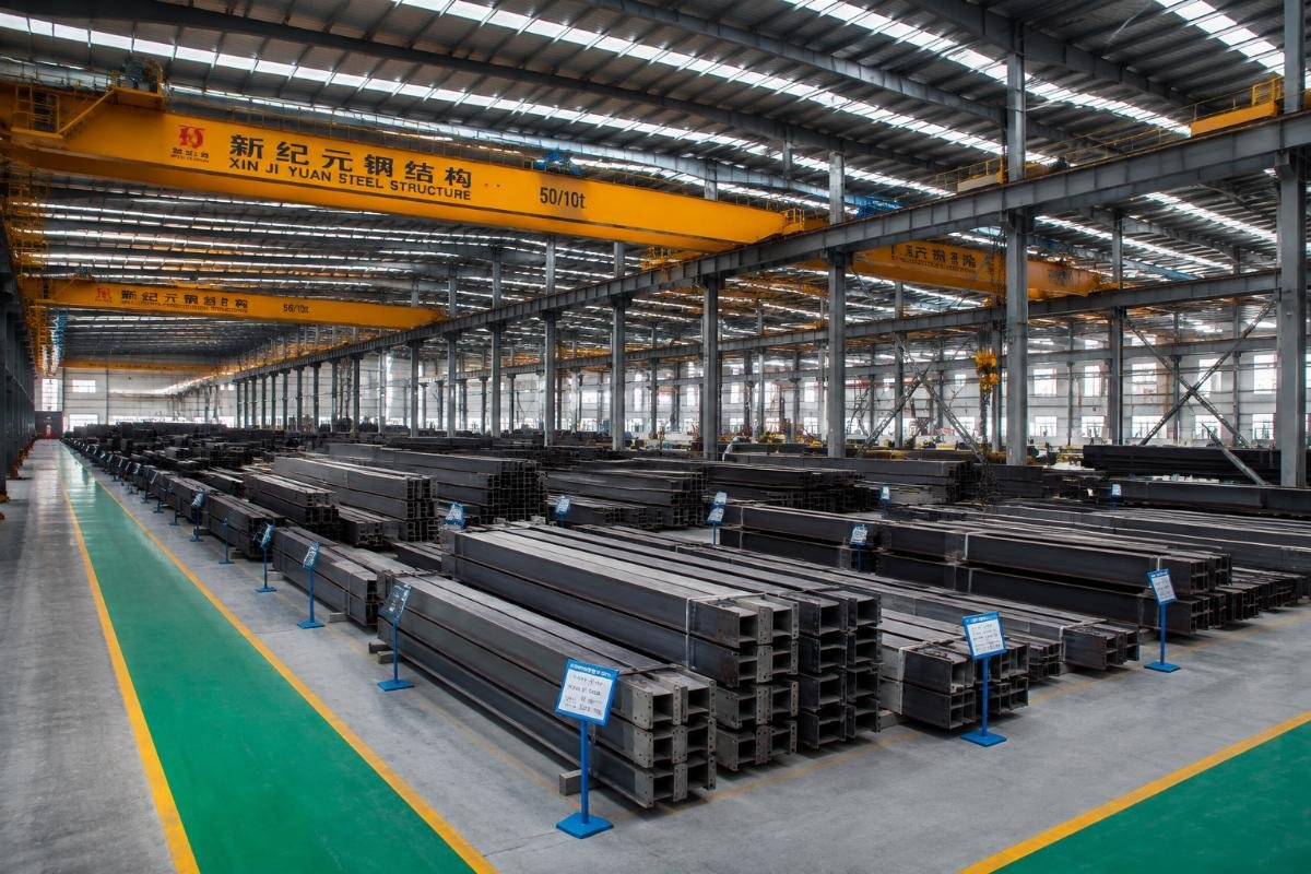 Wide shot of Xin Jiyuan’s modern steel production facility with organized storage of finished structural steel products